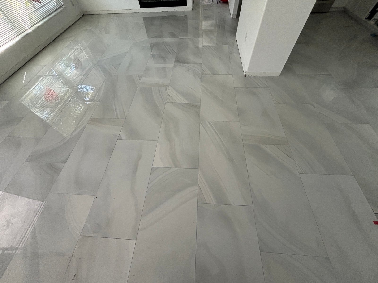 Polished rectangular floor tile installed in an offset pattern